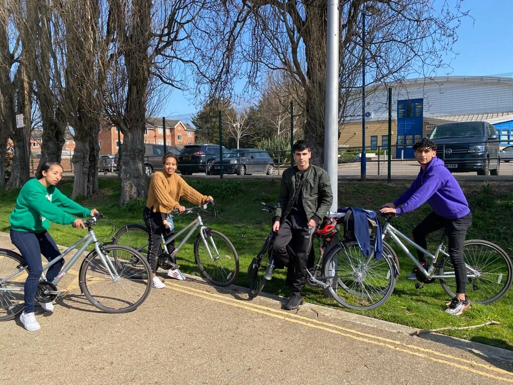 Young people on a group cycle ride through a London park