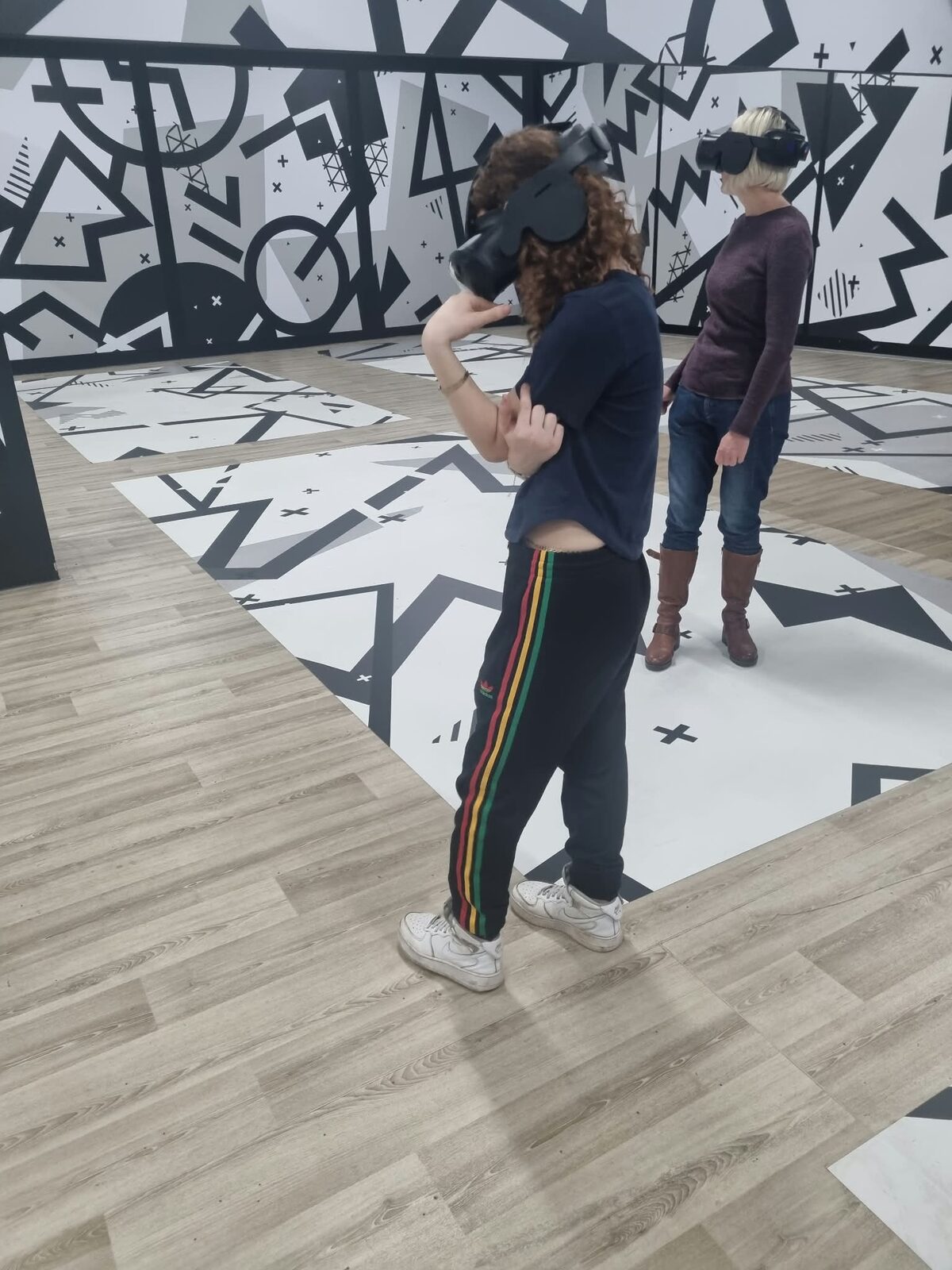 A young person and staff member trying a VR experience